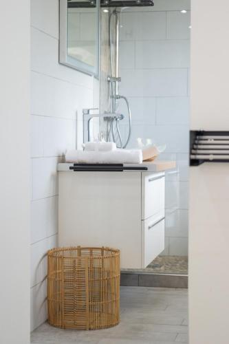 a bathroom with a sink and a basket at Studio Mare Gaillard in Le Gosier