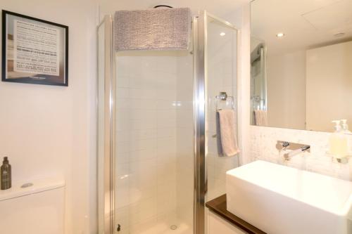 y baño con lavabo y ducha. en Relaxing, light-filled city apartment, en Melbourne