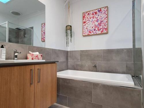 a bathroom with a bath tub and a sink at Spacious 3-bedroom home close to town and beach in Saint Leonards