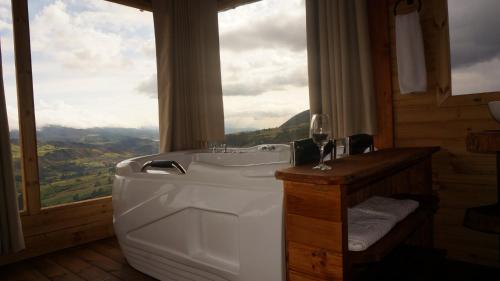 a bathroom with a bath tub and a window at Kajú Mirador Guatavita in Guatavita