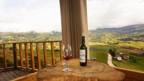 a bottle of wine sitting on a table with a glass at Kajú Mirador Guatavita in Guatavita