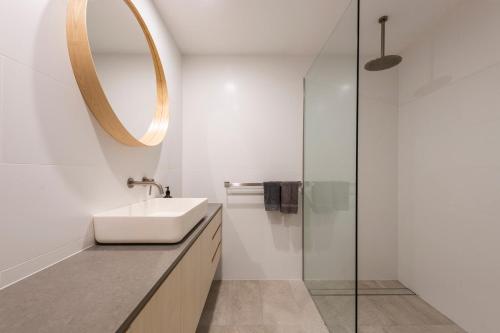 a bathroom with a sink and a mirror at Yamba Views Angourie Views Apartment in Yamba