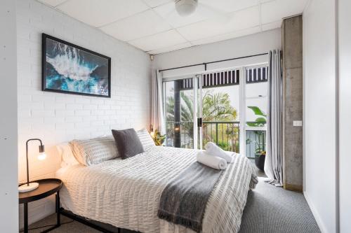 ein Schlafzimmer mit einem Bett und einem großen Fenster in der Unterkunft Yamba Views Angourie Views Apartment in Yamba