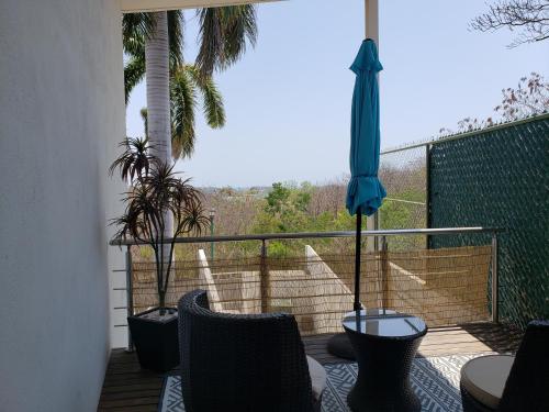 eine Terrasse mit Tisch und Stühlen und einem Sonnenschirm in der Unterkunft PuntaGaviota in Santa Cruz Huatulco
