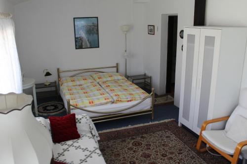 a bedroom with a bed and a couch and a chair at Pension Hanspaulka in Prague