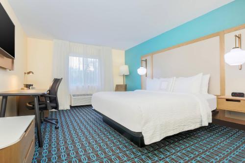 ein Hotelzimmer mit einem großen Bett und einem Schreibtisch in der Unterkunft Fairfield Inn & Suites Houston Humble in Humble