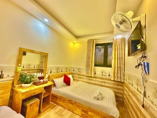 1 dormitorio con cama, espejo y ventilador en Khách Sạn Minh Hà Đà Lạt, en Da Lat