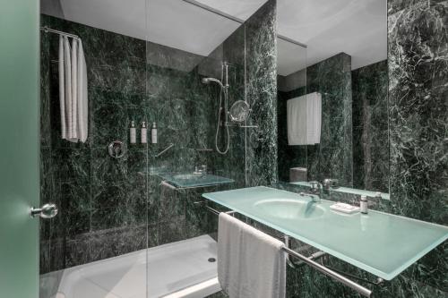 a bathroom with a sink and a shower and a tub at AC Hotel Alcalá de Henares by Marriott in Alcalá de Henares