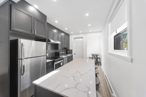 a kitchen with a white counter and a refrigerator at Stonewall Suites in Montréal
