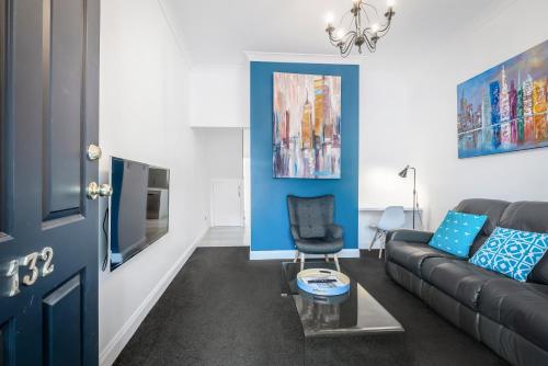 a living room with a couch and a blue wall at Brisbane Terrace - 3 Bedroom Hobart Inner City - Free Parking in Hobart