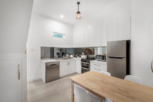 a kitchen with white cabinets and stainless steel appliances at Brisbane Terrace - 3 Bedroom Hobart Inner City - Free Parking in Hobart
