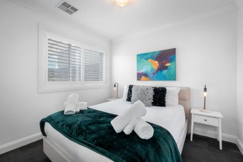 a bedroom with a bed with white sheets and a window at Brisbane Terrace - 3 Bedroom Hobart Inner City - Free Parking in Hobart