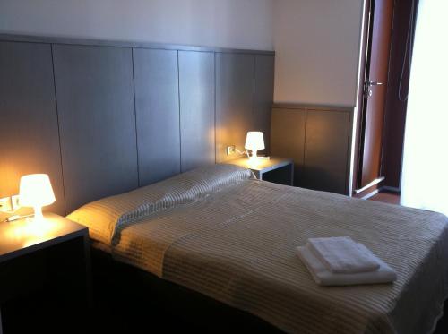 a bedroom with a bed with two lamps on it at Hotel Europa in Grado