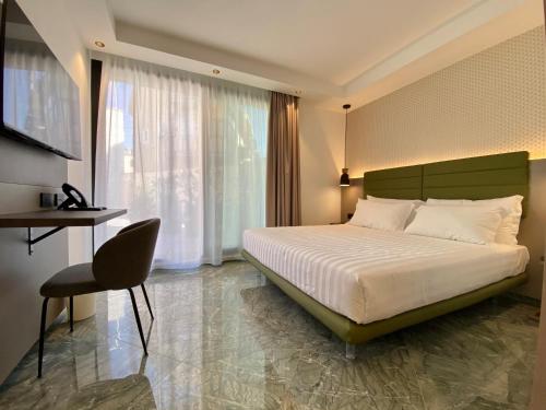 sypialnia z łóżkiem, krzesłem i oknem w obiekcie Salemare Rooms & Suites w Cefalù