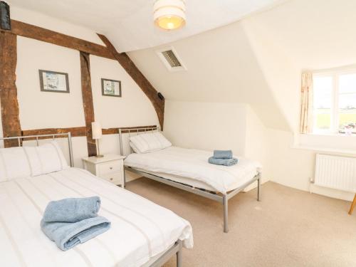 two twin beds in a room with a window at West Henstill House in Crediton