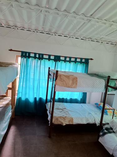 a bedroom with two bunk beds and a blue curtain at Finca villa sofia in Albán