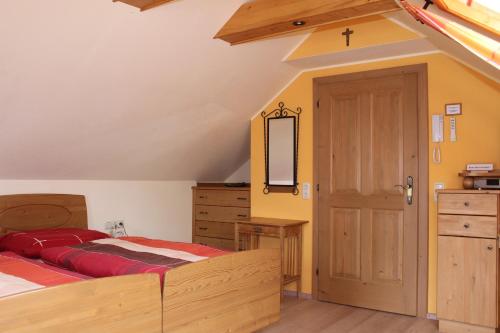 a bedroom with a bed and a wooden door at Pension Wenger in Kirchheim im Innkreis