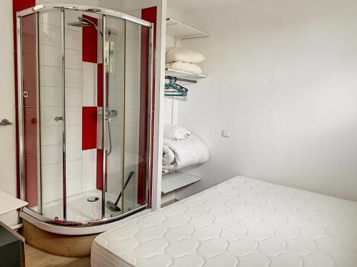 Cette chambre comprend un lit et une salle de bains pourvue d'une douche. dans l'établissement Appartement Central avec Terrasse Privative, Ascenseur, et Proche Plage - FR-1-361-353, à Granville