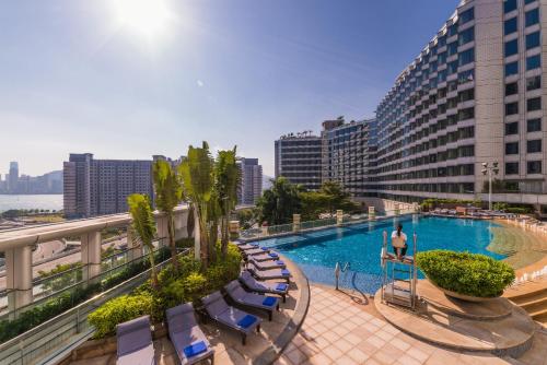 香港的住宿－香港都會海逸酒店，游泳池位于带椅子的阳台和大楼内