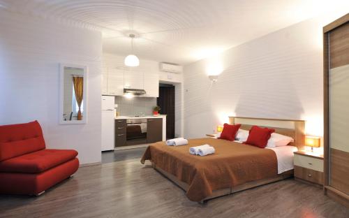 a bedroom with a bed and a red chair at Rooms & Apartments 72 in Zadar