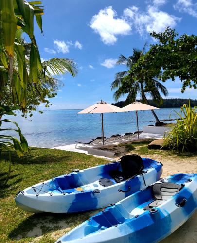 a blue kayak sitting on a beach next to the ocean at Moorea Island Beach Hotel in Moorea