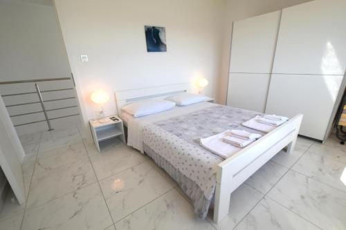 a bedroom with a white bed with towels on it at Villa Isabella in Linardići