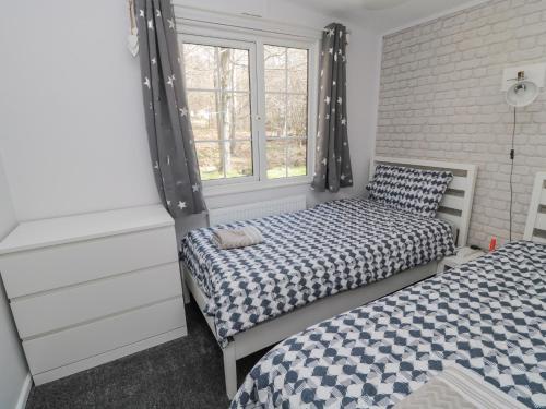 a bedroom with two beds and a window at Betty's Lodge in Morpeth