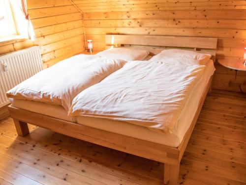 a large bed in a room with wooden walls at Semi-detached house, Hasselfelde in Hasselfelde