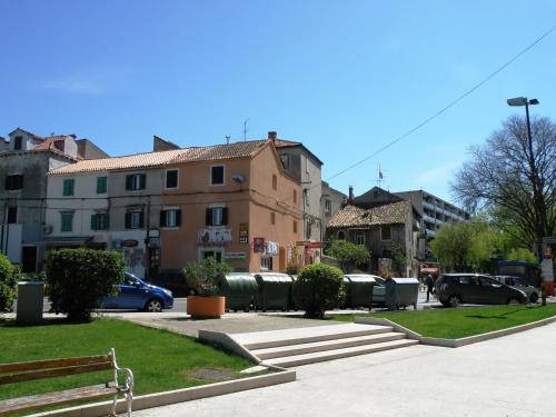 a park with a bench and some buildings and cars at Apartment Central in Šibenik