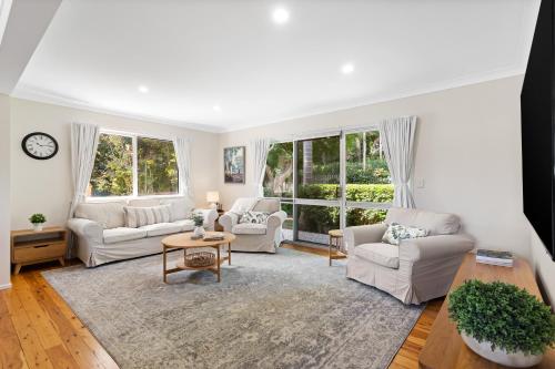 a living room with white furniture and large windows at Maple Cottage - Perfect Eastside Location in Toowoomba