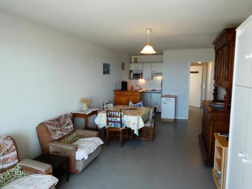 un salon avec une table et une cuisine dans l'établissement Notre-Dame-de-Monts - Appartement 45m² - 4 pers - Animaux admis - Parking - FR-1-540-192, à Notre-Dame-de-Monts