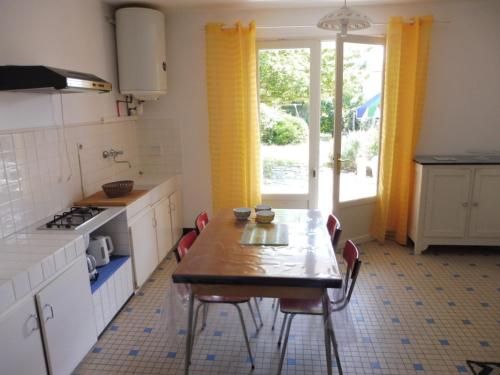 une cuisine avec une table et des chaises et une fenêtre dans l'établissement Charmante maison à 600m de la plage, 4 pers, terrasse et jardin, quartier tranquille - FR-1-540-221, à Notre-Dame-de-Monts