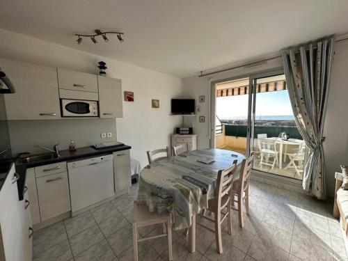 une cuisine et une salle à manger avec une table et un balcon dans l'établissement 