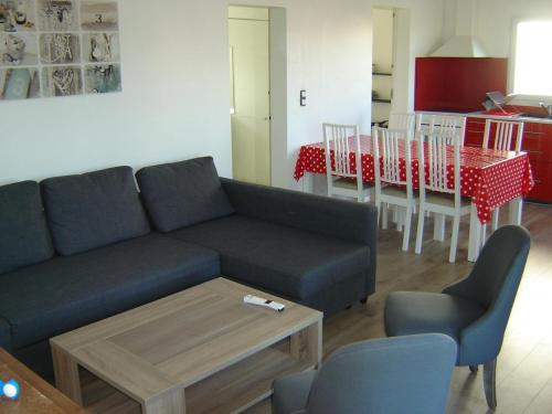 un salon avec un canapé et une table avec des chaises dans l'établissement Maison rénovée proche plage à Notre-Dame-de-Monts - 6 pers, wifi, vélos, jardin, animaux OK - FR-1-540-227, à Notre-Dame-de-Monts
