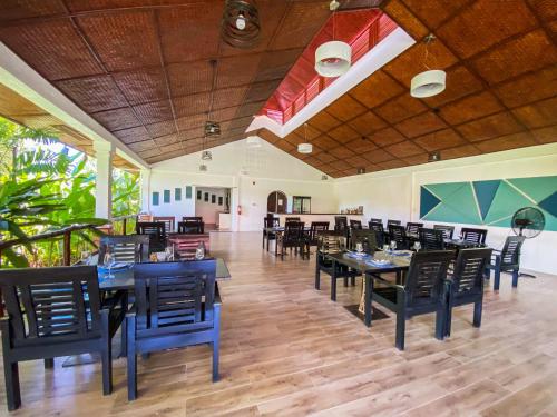 uma sala de jantar com mesas e cadeiras pretas em Carpe Diem Villas & Resort em Puerto Princesa