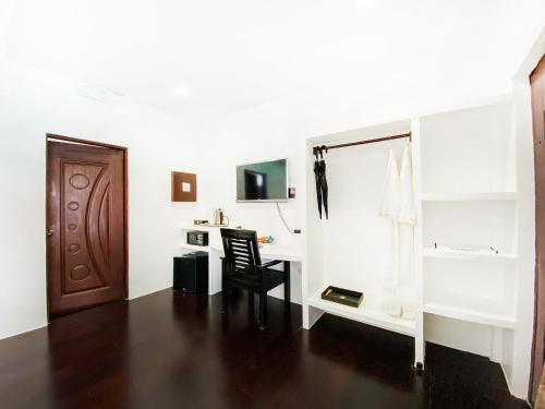 a white room with a desk and a chair at Carpe Diem Villas & Resort in Puerto Princesa City