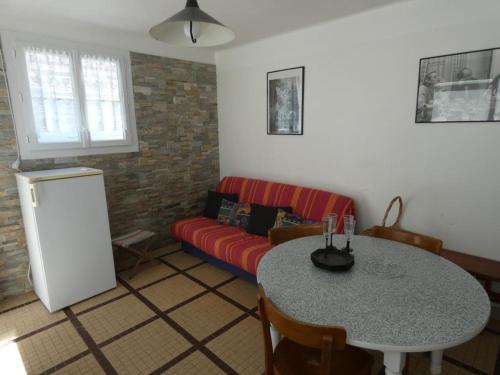 un salon avec un canapé rouge et une table dans l'établissement Appartement cosy à 100m de la plage – 5 pers, Équipé, 33m², Parking, Notre-Dame-de-Monts - FR-1-540-239, à Notre-Dame-de-Monts
