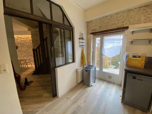 - une cuisine avec une grande porte en verre dans une pièce dans l'établissement Maison Belle Époque à Royan avec Terrasse, 200m Plage - FR-1-494-157, à Royan