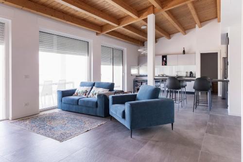 een woonkamer met een blauwe bank en een keuken bij Come a casa - Feels like home in Polignano a Mare