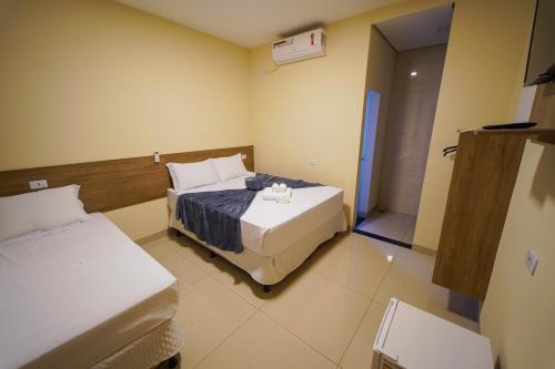 a hotel room with two beds and a bathroom at Verdant hotel in Bonito