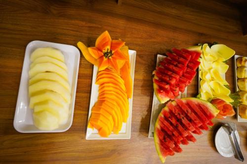 a wooden table with three plates of fruit on them at Verdant hotel in Bonito
