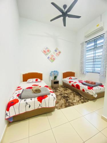 a bedroom with two beds and a ceiling fan at SARASERA HOMESTAY with PRIVATE POOL MELAKA in Melaka