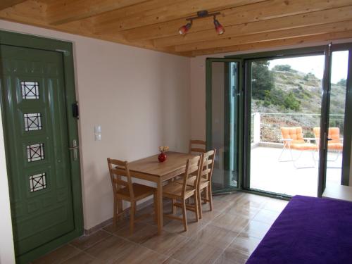 a dining room with a wooden table and chairs at Porto Katsiki Blu in Athani