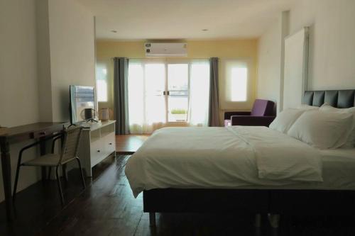 a hotel room with a bed and a desk with a computer at Riverfront house/Chao phraya river/Baan Rimphraya in Bangkok