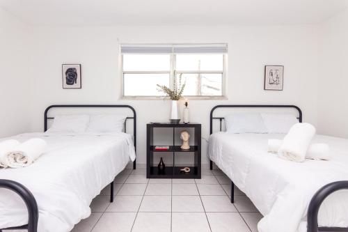 - 2 lits installés l'un à côté de l'autre dans une chambre dans l'établissement Two Bedroom Apartment - with Parking & Balcony - Heart of Wynwood, à Miami