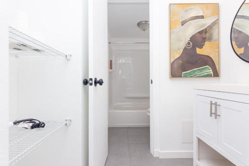 une salle de bains avec une peinture d'une femme dans un chapeau dans l'établissement Two Bedroom Apartment - with Parking & Balcony - Heart of Wynwood, à Miami