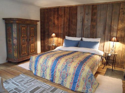 1 dormitorio con 1 cama y pared de madera en Romantische Ferienhütte Ennstaler Nat Kalkalpen bis 6 Personen en Kleinreifling