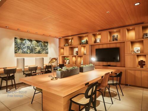 a conference room with a large table and a flat screen tv at First Cabin Nishi Umeda in Osaka