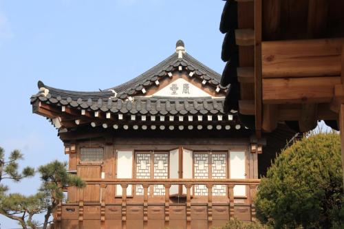 an asian house with a roof and a fence at HanokInn in Gyeongju