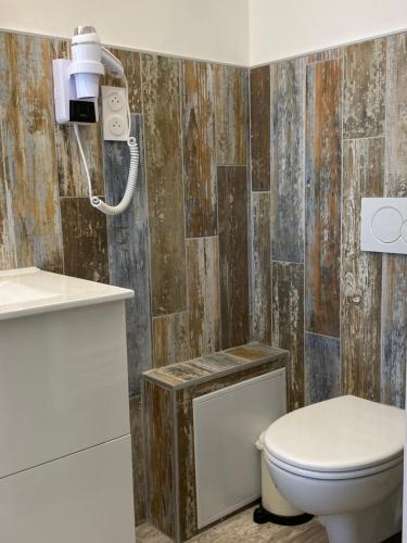 a bathroom with a toilet and a camera on the wall at Hôtel Le Neptune en Camargue in Saintes-Maries-de-la-Mer